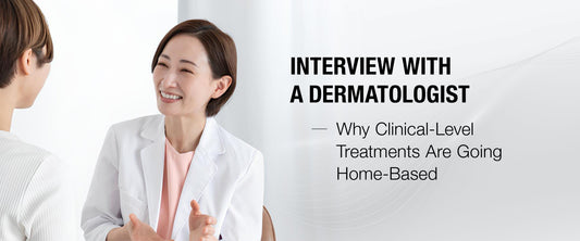 Woman applying anti-aging serum at home with LED mask in background